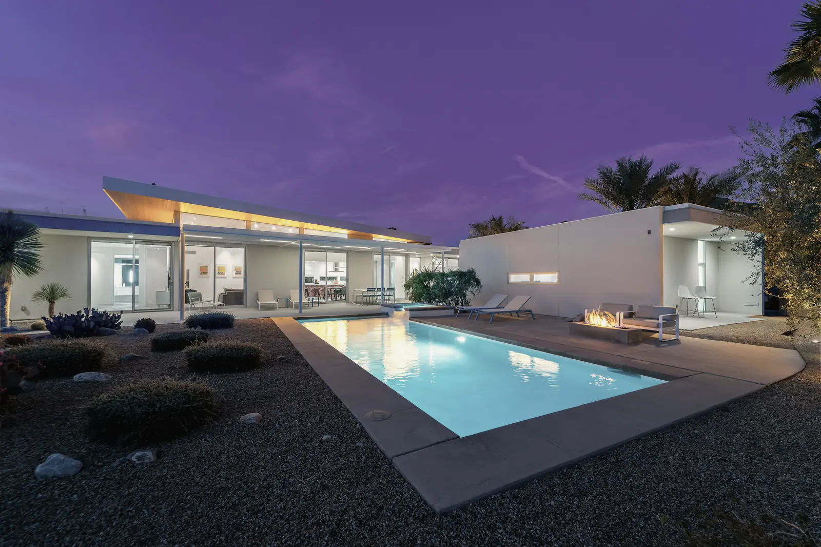 A single-level desert home and its pool at blue hour