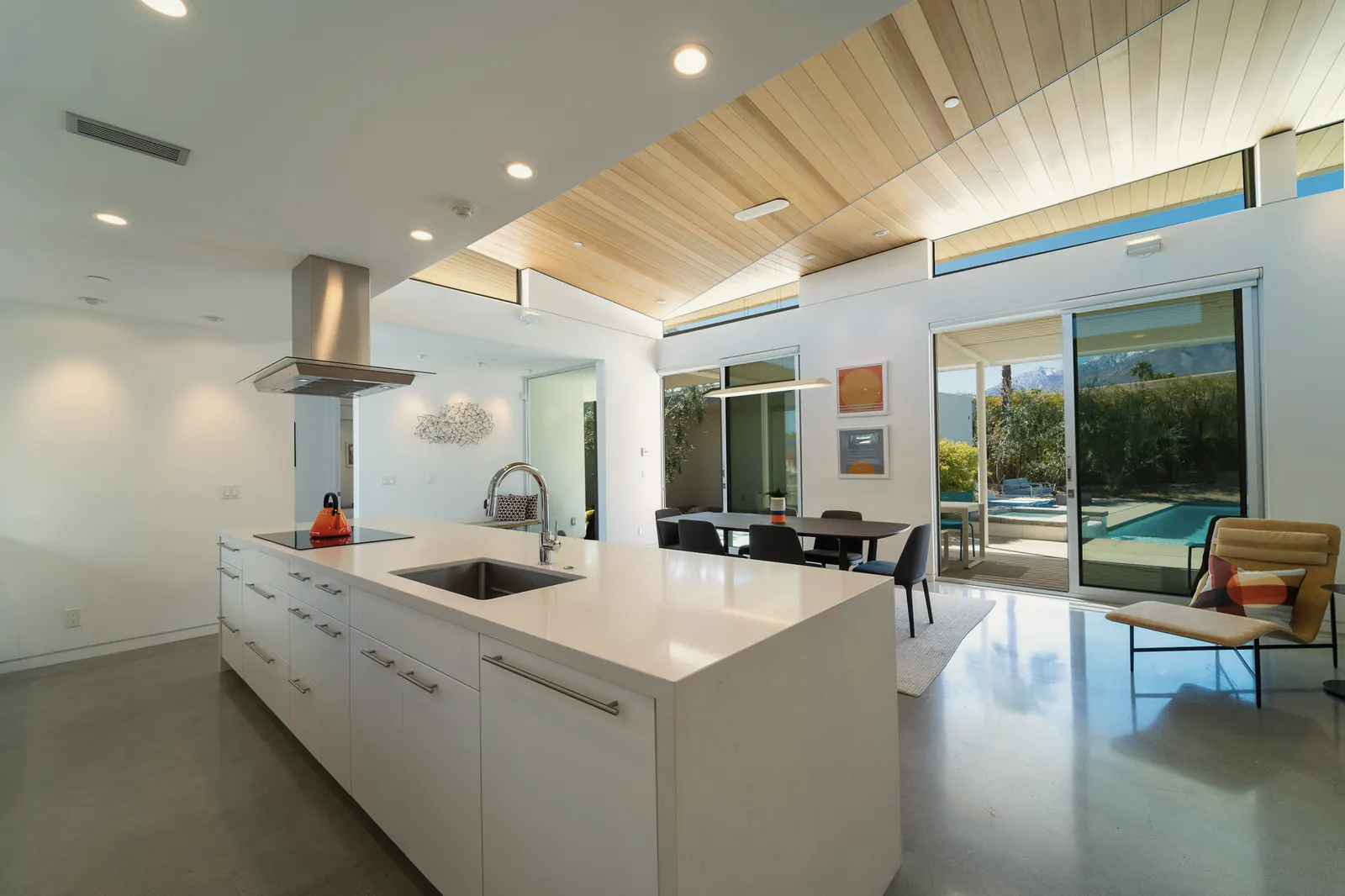An open kitchen with a long white island under clerestory windows