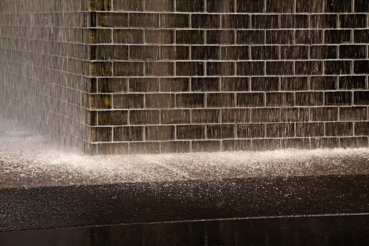 Water pouring down a tiled wall